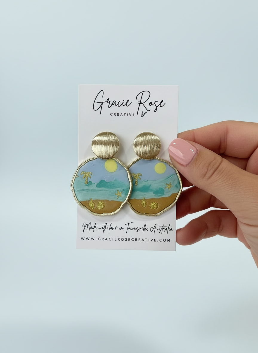Close-up of Beach Day Bliss earrings by Gracie Rose Creative held in hand, displaying unique handmade details and colorful coastal artwork.