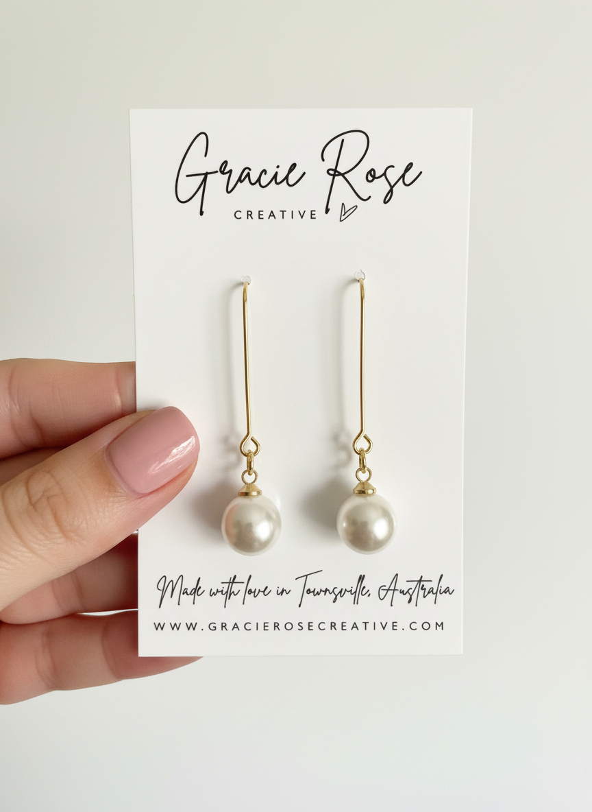 Close-up of Timeless Pearl Drops by Gracie Rose Creative, featuring lustrous man-made pearls on gold-tone hooks, displayed on branded packaging.