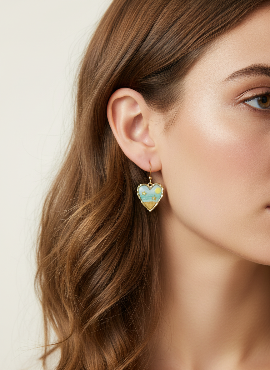 Model wearing 'Seaside Sweetheart' heart earrings by Gracie Rose Creative, showcasing their vibrant ocean-inspired colors against a soft backdrop.