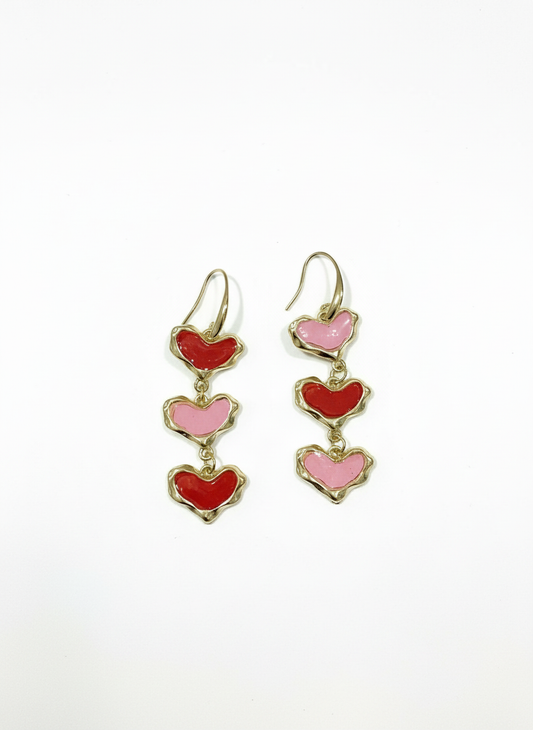 The Sweetheart Stack triple heart drop earrings in red and blush pink polymer clay with gold-tone setting, handmade by Gracie Rose Creative.