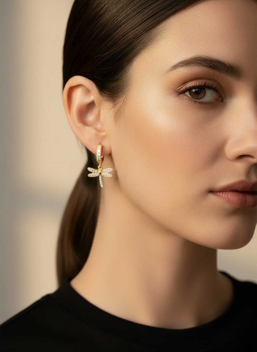 Model wearing Dragonfly Drops earrings by Gracie Rose Creative, featuring radiant gold huggies with shimmering dragonfly charms.