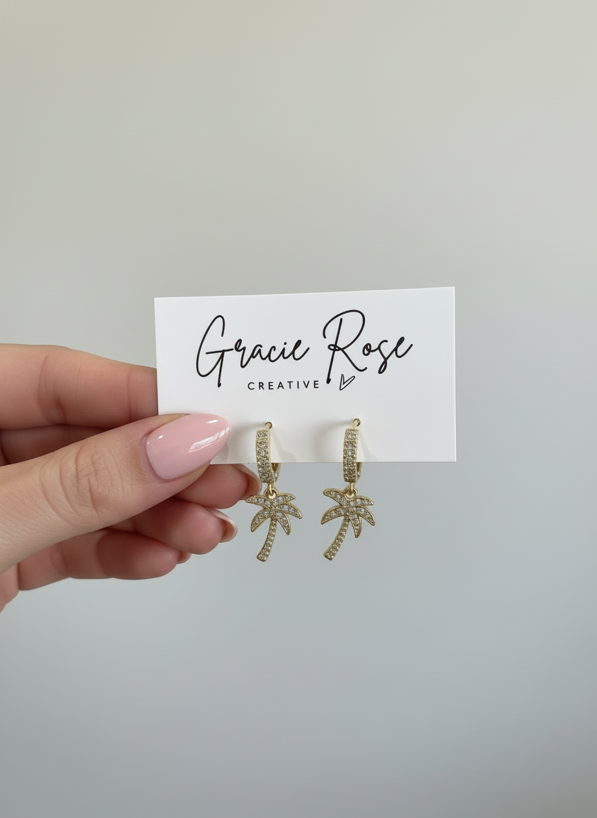 Elegant golden palm earrings from Gracie Rose Creative, featuring refined gold palm drops and sparkling crystal accents, embodying coastal elegance.