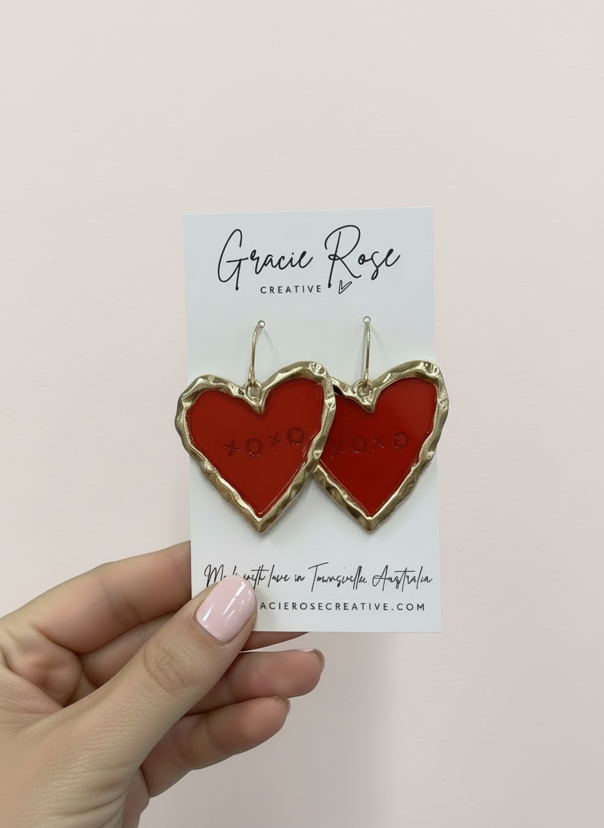 Stylish red XOXO earrings hanging, perfect for adding charm to any outfit, made with love from polymer clay.