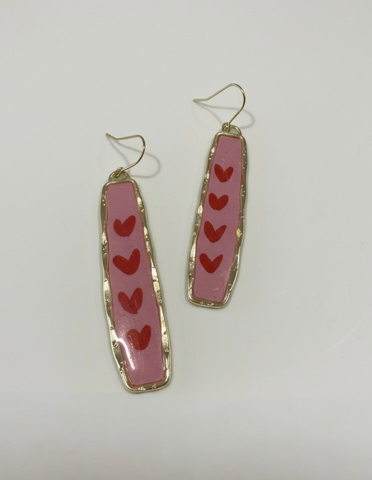 Handmade pink earrings titled 'Endless Love' featuring playful red hearts, perfect for adding a love-filled touch to any outfit.