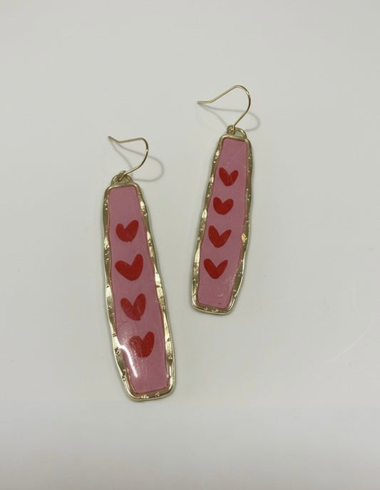 Handmade pink earrings titled 'Endless Love' featuring playful red hearts, perfect for adding a love-filled touch to any outfit.