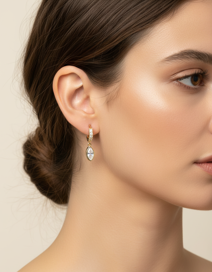 Model wearing the Halo Drop Huggies by Gracie Rose Creative, displaying the elegant design of the earrings with a marquise-cut crystal drop.