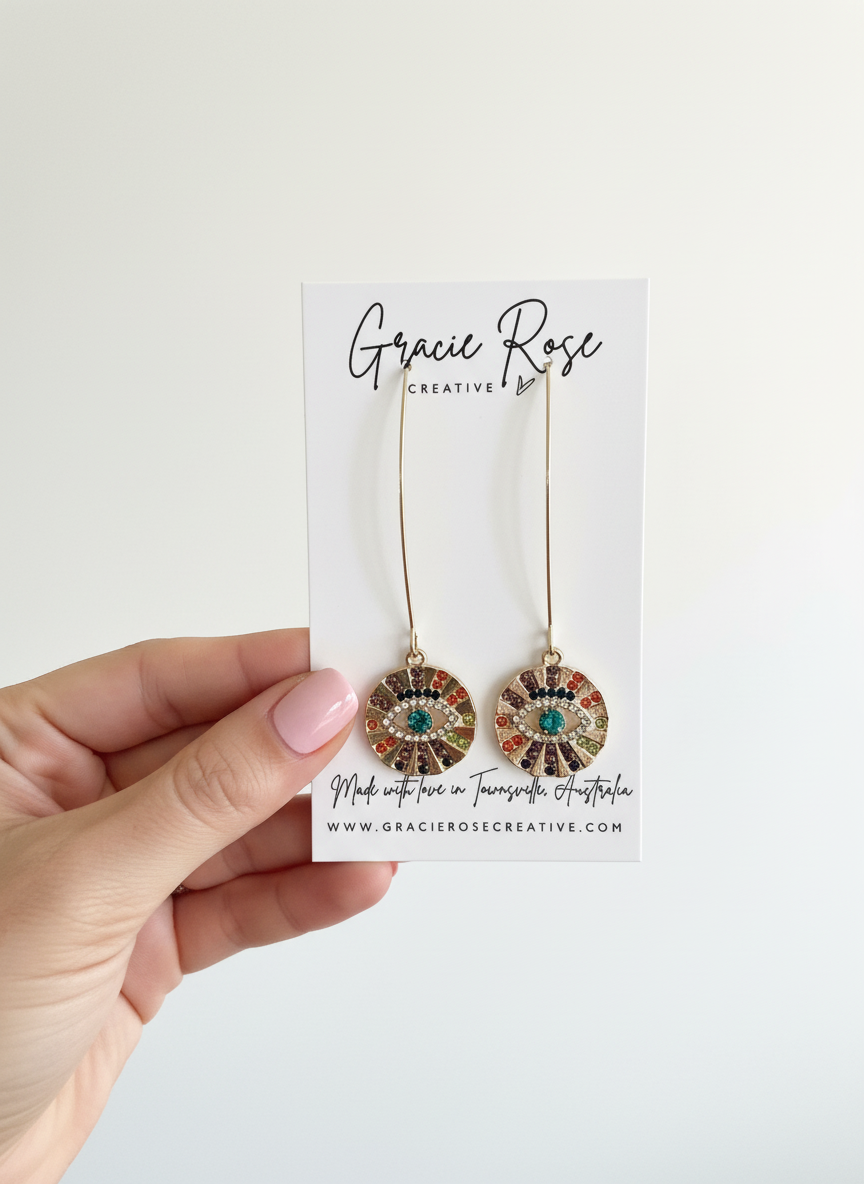 Rainbow Evil Eye Drop Earrings by Gracie Rose Creative held in hand, highlighting their unique design and packaging, ideal for gifting or personal style.