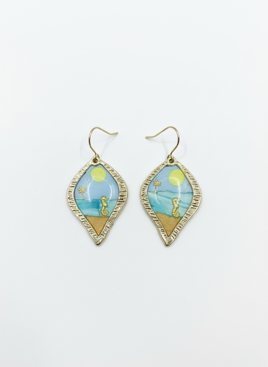 Stylish handmade drop earrings named Costal Daydream, featuring tranquil blue tones and sandy hues, showcasing delicate gold detailing.