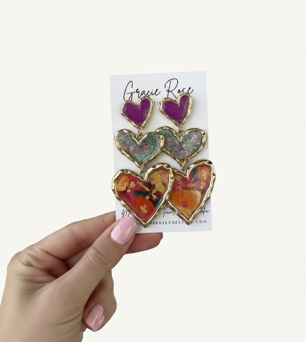 Hand holding a card displaying beautiful handmade heart earrings by Gracie Rose Creative - Cross Your Heart (floral sparkle).