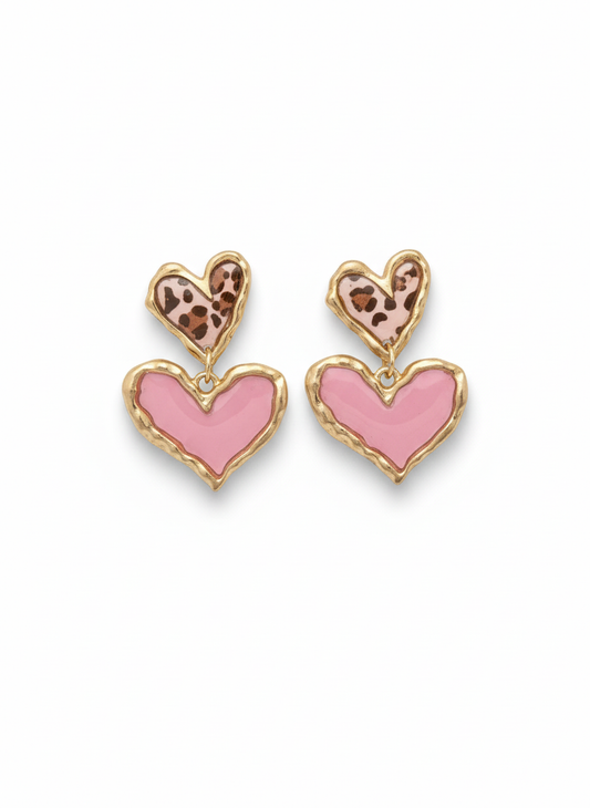 Stylish Cross Your Heart earrings in pink leopard print, featuring a double heart design with glossy bubblegum pink accents and a textured gold-tone frame, perfect for making a statement.